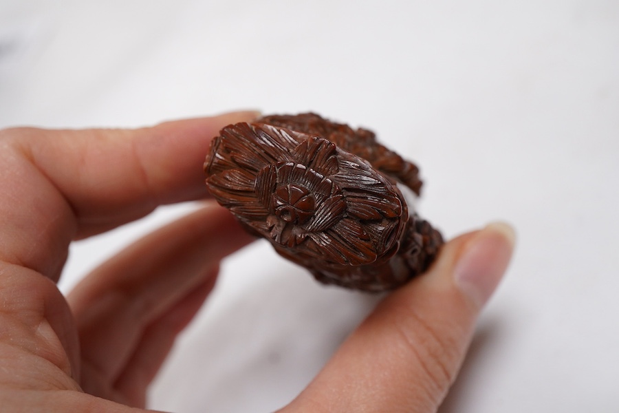 An 18th / 19th century European carved figural coquilla nut snuff box, 8.5cm wide